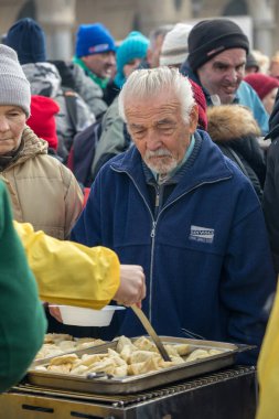 Krakov, Polonya - 17 Aralık 2017: Noel arifesi yoksul ve Cracow ana meydanında evsizlere için. Her yıl grup Kosciuszko Polonya açık havada büyük eve hazırlar.