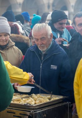 Krakov, Polonya - 17 Aralık 2017: Noel arifesi yoksul ve Cracow ana meydanında evsizlere için. Her yıl grup Kosciuszko Cracow açık havada büyük eve hazırlar. Polonya