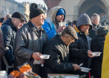 Cracow, Poland - December 17, 2017:   Christmas Eve for poor and homeless on the Main Square in Cracow. Every year the group Kosciuszko prepares the greatest eve in the open air in Cracow. Poland clipart