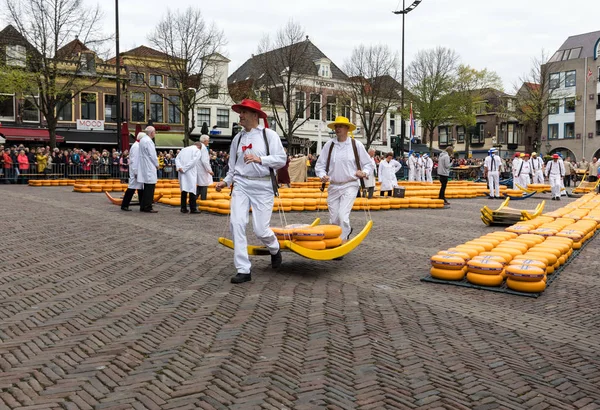 Alkmaar, Hollanda - 21 Nisan 2017: Alkmaar, Hollanda ünlü Hollandalı peynir pazarında birçok peynir ile yürüyüş uçak gemisi. Waagplein Meydanı'nda olay olur. 