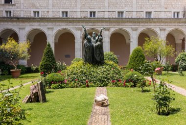 Montecassino, Italy - June 17, 2017: The entrance cloister of Monte Cassino Abbey and the death of Saint Benedict Statue. Italy clipart