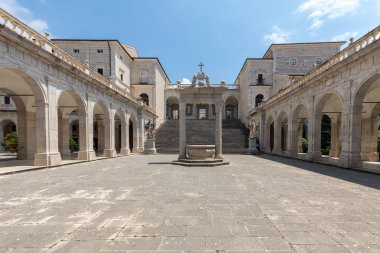 Montecassino, Italy - June 17, 2017: Cistern and statues of St. Benedict and St. Scholastica in the Cloister of Bramante, Benedictine abbey of Montecassino. Italy clipart