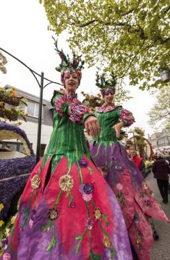 Noordwijkerhout, Hollanda - 21 Nisan 2017: Renkli elbise geleneksel çiçek, stilts üzerinde yürüyen kadınlarda Bloemencorso Noordwijk Hollanda'da Haarlem için geçit töreni