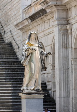 Montecassino, Italy - June 17, 2017: Marble statue of St. Scholastica by P. Campi of Carrara, in the Cloister of Bramante, Benedictine abbey of Montecassino. Italy clipart