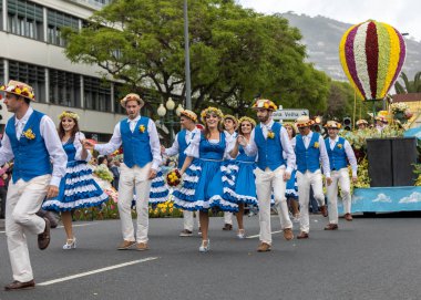 Funchal; Madeira; Portekiz - 22 Nisan; 2018: bir grup insan renkli kostümleri dans Madeira çiçek Festivali geçit töreninde Funchal, Madeira Adası üzerinde. Portekiz.