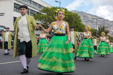 Funchal; Madeira; Portekiz - 22 Nisan; 2018: bir grup insan ayçiçeği motifli renkli elbiseler dans Madeira çiçek Festivali geçit töreninde Funchal, Madeira Adası üzerinde. Portekiz.