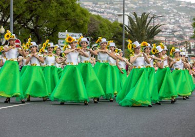 Funchal; Madeira; Portekiz - 22 Nisan; 2018: ayçiçeği motifli renkli elbiseler kız bir grup dans Madeira çiçek Festivali geçit töreninde Funchal, Madeira Adası üzerinde. Portekiz.