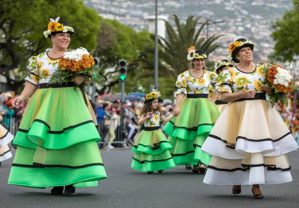 Funchal; Madeira; Portekiz - 22 Nisan; 2018: bir grup kadın ayçiçeği motifli renkli elbiseler dans Madeira çiçek Festivali geçit töreninde Funchal, Madeira Adası üzerinde. Portekiz.