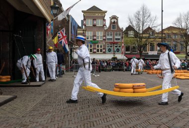 Alkmaar, Hollanda - 21 Nisan 2017: Alkmaar, Hollanda ünlü Hollandalı peynir pazarında birçok peynir ile yürüyüş uçak gemisi. Waagplein Meydanı'nda olay olur. 