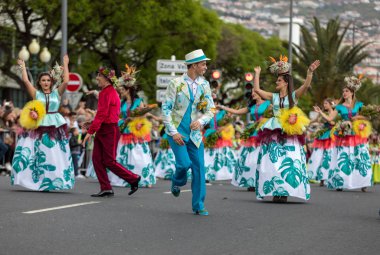 Funchal; Madeira; Portekiz - 22 Nisan; 2018: bir grup insan renkli kostümleri dans Madeira çiçek Festivali geçit töreninde Funchal, Madeira Adası üzerinde. Portekiz.