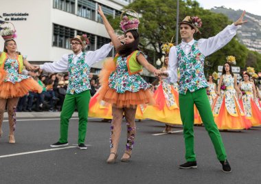 Funchal; Madeira; Portekiz - 22 Nisan; 2018: bir grup insan renkli kostümleri dans Madeira çiçek Festivali geçit töreninde Funchal, Madeira Adası üzerinde. Portekiz.