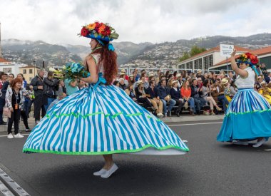 Funchal; Madeira; Portekiz - 22 Nisan; 2018: bir grup kadın renkli kostümleri dans Madeira çiçek Festivali geçit töreninde Funchal, Madeira Adası üzerinde. Portekiz.