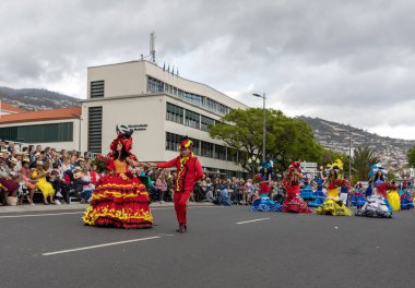 Funchal; Madeira; Portekiz - 22 Nisan; 2018: bir grup insan renkli kostümleri dans Madeira çiçek Festivali geçit töreninde Funchal, Madeira Adası üzerinde. Portekiz.