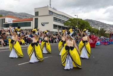 Funchal; Madeira; Portekiz - 22 Nisan; 2018: bir grup kadın renkli kostümleri dans Madeira çiçek Festivali geçit töreninde Funchal, Madeira Adası üzerinde. Portekiz.