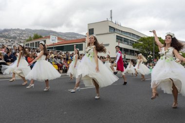 Funchal; Madeira; Portekiz - 22 Nisan; 2018: bir grup insan renkli kostümleri dans Madeira çiçek Festivali geçit töreninde Funchal, Madeira Adası üzerinde. Portekiz.