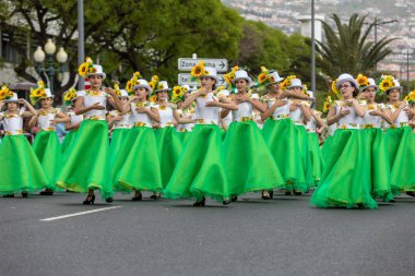 Funchal; Madeira; Portekiz - 22 Nisan; 2018: ayçiçeği motifli renkli elbiseler kız bir grup dans Madeira çiçek Festivali geçit töreninde Funchal, Madeira Adası üzerinde. Portekiz.