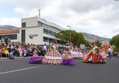 Funchal; Madeira; Portekiz - 22 Nisan; 2018: bir grup insan renkli kostümleri dans Madeira çiçek Festivali geçit töreninde Funchal, Madeira Adası üzerinde. Portekiz.