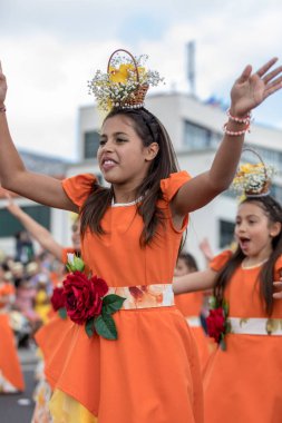 Funchal; Madeira; Portekiz - 22 Nisan; 2018: Turuncu kostümleri kız bir grup dans Madeira çiçek Festivali geçit töreninde Funchal, Madeira Adası üzerinde. Portekiz.