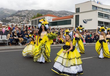 Funchal; Madeira; Portekiz - 22 Nisan; 2018: bir grup kadın renkli kostümleri dans Madeira çiçek Festivali geçit töreninde Funchal, Madeira Adası üzerinde. Portekiz.