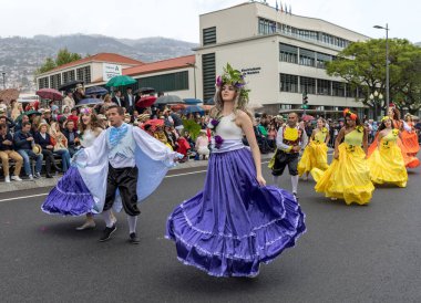 Funchal; Madeira; Portekiz - 22 Nisan; 2018: bir grup insan renkli kostümleri dans Madeira çiçek Festivali geçit töreninde Funchal, Madeira Adası üzerinde. Portekiz.