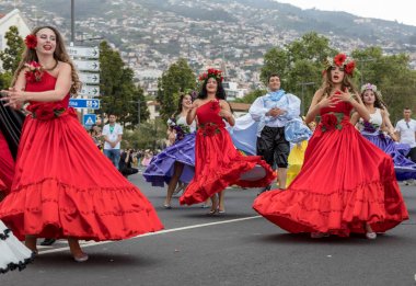 Funchal; Madeira; Portekiz - 22 Nisan; 2018: bir grup insan renkli kostümleri dans Madeira çiçek Festivali geçit töreninde Funchal, Madeira Adası üzerinde. Portekiz.