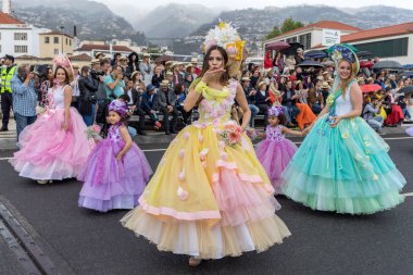 Funchal; Madeira; Portekiz - 22 Nisan; 2018: bir grup insan renkli kostümleri dans Madeira çiçek Festivali geçit töreninde Funchal, Madeira Adası üzerinde. Portekiz.