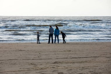 Katwijk, Hollanda - 23 Nisan 2017: Güneşli bir günde Katwijk plaj boyunca insanlar yürüyor. Hollanda