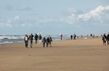 Katwijk, Hollanda - 23 Nisan 2017: Güneşli bir günde Katwijk plaj boyunca insanlar yürüyor. Hollanda