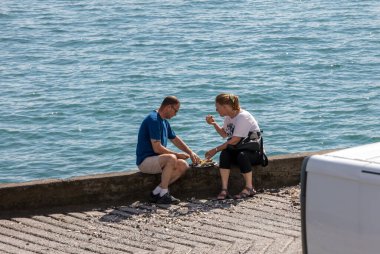 Cancale, Fransa - 15 Eylül 2018: Cancale, Brittany, Fransa 'da deniz kenarında istiridye yiyen çift
