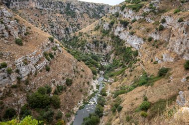 Gravina nehir kanyonu manzarası ve Matera Rupestrian Kiliseleri parkı, antik Matera (Sassi), Basilicata, İtalya yakınlarındaki di Murgia Timone mağaralarında evler.