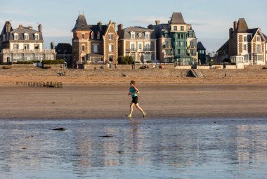Saint-Malo, Fransa - 16 Eylül 2018: Saint-Malo, Brittany, Fransa 'da plaj boyunca koşan kadın