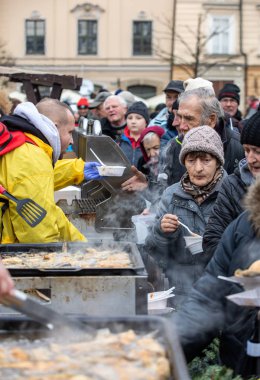 Cracow, Polonya - 15 Aralık 2019: Krakow 'daki ana meydandaki fakir ve evsizler için Noel arifesi. Kosciuszko grubu her yıl Krakow 'un açık havasının en güzel arifesini hazırlar. Polonya