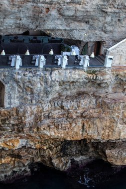Polignano a Mare, İtalya - 17 Eylül 2019: Polignano a Mare, Puglia, İtalya 'daki kayalıklarda bulunan dünyaca ünlü Grotta Palazzese restoranı 