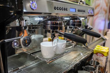 Cracow, Polonya - 20 Kasım 2019: Barista Gastrofood 'daki kahve makinesinde kahve yapıyor - Krakow' da yiyecek ve içecek için ticaret fuarı. Polonya