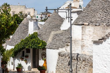 Alberobello, İtalya - 16 Eylül 2019: Trulli köyünde geleneksel beyaz evler. Alberobello, İtalya. Yapım tarzı İtalya 'nın Apulia bölgesindeki Murge bölgesine özgüdür (İtalyan Puglia bölgesinde). Kireç taşı ve temel taştan yapılmış..
