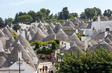 Alberobello, İtalya - 16 Eylül 2019: Trulli köyünde geleneksel beyaz evler. Alberobello, İtalya. Yapım tarzı İtalya 'nın Apulia bölgesindeki Murge bölgesine özgüdür (İtalyan Puglia bölgesinde). Kireç taşı ve temel taştan yapılmış..