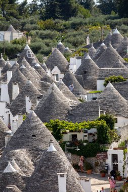 Alberobello, İtalya - 16 Eylül 2019: Trulli köyünde geleneksel beyaz evler. Alberobello, İtalya. Yapım tarzı İtalya 'nın Apulia bölgesindeki Murge bölgesine özgüdür (İtalyan Puglia bölgesinde). Kireç taşı ve temel taştan yapılmış..