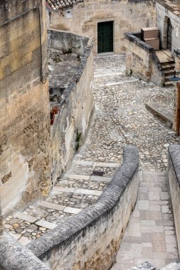 Matera şehrinin tarihi bir bölgesi olan Sassi di Matera 'da bir ara sokaktaki tipik kaldırımlı merdivenler. Basilicata. İtalya