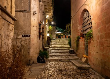 Matera, İtalya - 19 Eylül 2019: Matera şehrinin tarihi bir bölgesi olan Sassi di Matera 'da bir ara sokaktaki tipik kaldırımlı merdivenler. Basilicata. İtalya