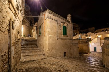 Matera şehrinin tarihi bir bölgesi olan Sassi di Matera 'da bir ara sokaktaki tipik kaldırımlı merdivenler. Basilicata. İtalya
