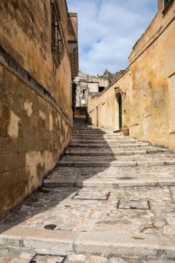 Matera şehrinin tarihi bir bölgesi olan Sassi di Matera 'da bir ara sokaktaki tipik kaldırımlı merdivenler. Basilicata. İtalya