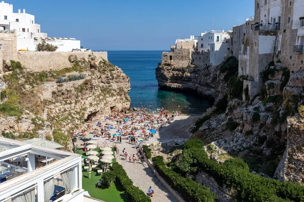 Polignano, İtalya - 17 Eylül 2019: İnsanlar Polignano a Mare, Adriyatik Denizi, Apulia, Bari ili, İtalya 'daki sevimli Lama Monachile plajında dinleniyor ve yüzüyorlar,