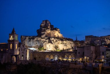 Matera, Italy - September 17, 2019: Night view at Church of San Pietro caveoso and on the top of the hill of Church of Saint Mary of Idris in Matera, Basilicata, Italy
