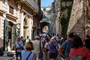 Matera, İtalya - 15 Eylül 2019: Matera şehrinin tarihi bir bölgesi olan Sassi di Matera 'daki Cobblestone caddesinde yürüyüş yapan turistler. Basilicata. İtalya