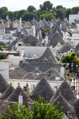 Alberobello, İtalya - 16 Eylül 2019: Trulli köyünde geleneksel beyaz evler. Alberobello, İtalya. Yapım tarzı İtalya 'nın Apulia bölgesindeki Murge bölgesine özgüdür (İtalyan Puglia bölgesinde). Kireç taşı ve temel taştan yapılmış..