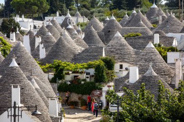 Alberobello, İtalya - 16 Eylül 2019: Trulli köyünde geleneksel beyaz evler. Alberobello, İtalya. Yapım tarzı İtalya 'nın Apulia bölgesindeki Murge bölgesine özgüdür (İtalyan Puglia bölgesinde). Kireç taşı ve temel taştan yapılmış..