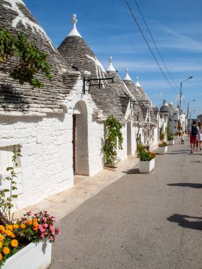 Alberobello, İtalya - 16 Eylül 2019: Trulli köyünde geleneksel beyaz evler. Alberobello, İtalya. Yapım tarzı İtalya 'nın Apulia bölgesindeki Murge bölgesine özgüdür (İtalyan Puglia bölgesinde). Kireç taşı ve temel taştan yapılmış..