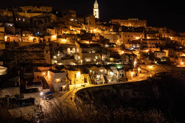 Matera 'daki antik Sassi bölgesinde geceleri, antik mağara evleri ile tanınan şaşırtıcı aydınlık binalar. Basilicata. İtalya