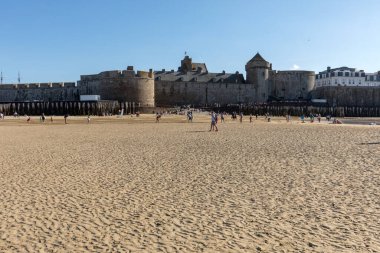 St. Malo, Fransa - 15 Eylül 2018: Saint Malo 'nun pitoresk plajında gün batımından önce insanların romantik yürüyüşü. Britanya, Fransa