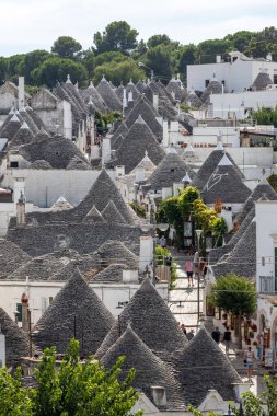 Alberobello, İtalya - 16 Eylül 2019: Trulli köyünde geleneksel beyaz evler. Alberobello, İtalya. Yapım tarzı İtalya 'nın Apulia bölgesindeki Murge bölgesine özgüdür (İtalyan Puglia bölgesinde). Kireç taşı ve temel taştan yapılmış..